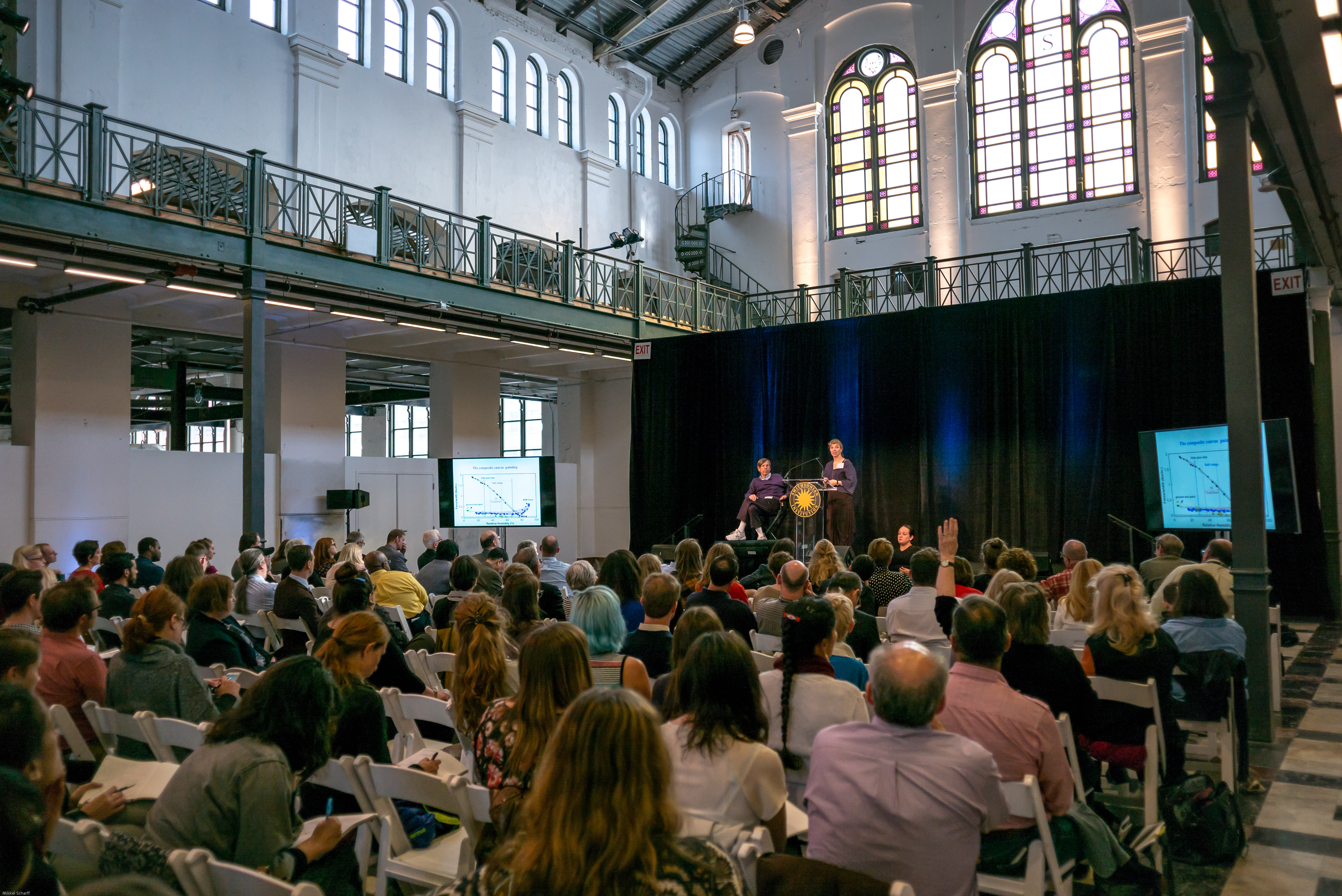 Introduction of presenter during symposium to a large crowd
